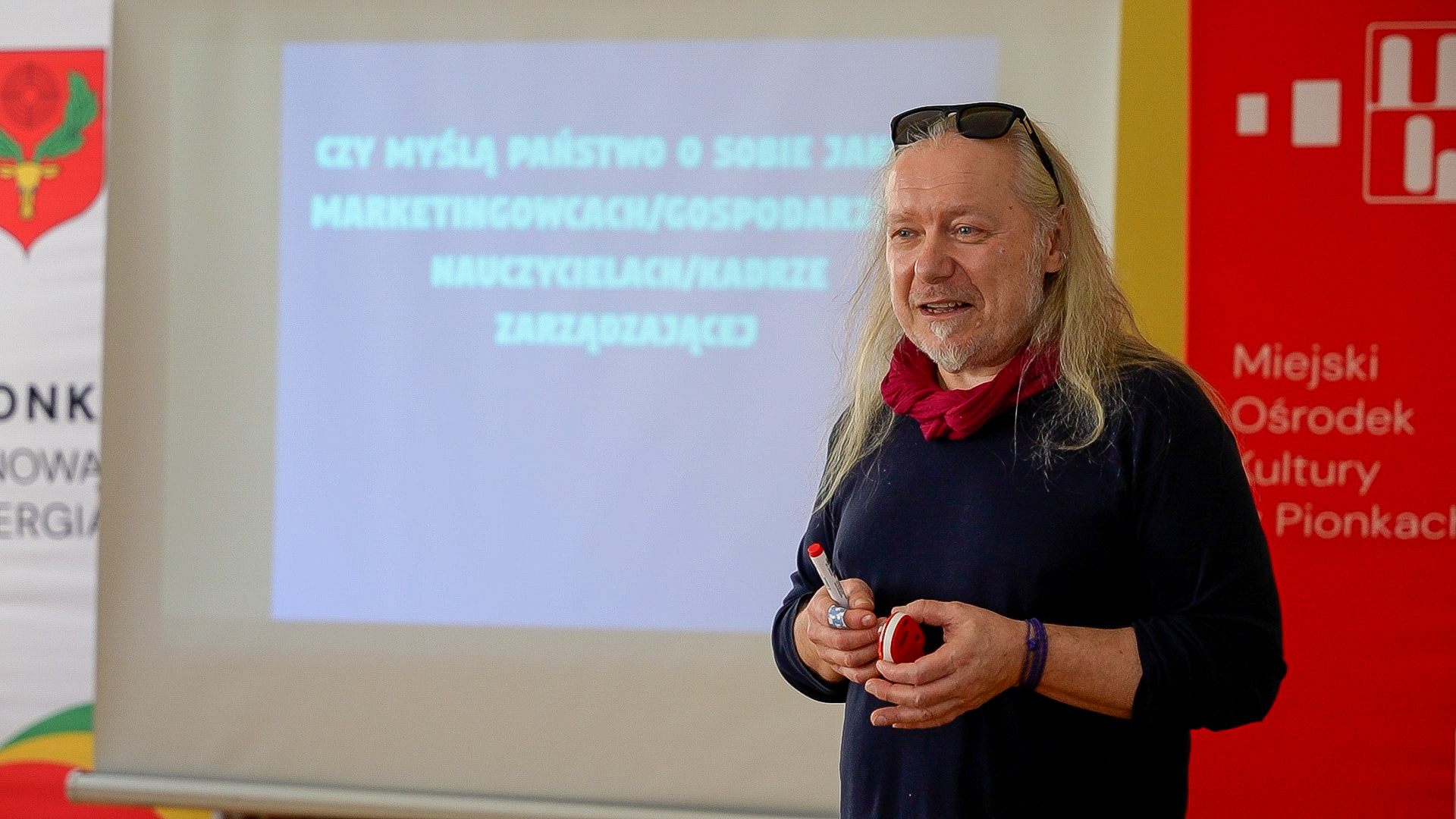 Prelegenci konferencji o kompetencjach komunikacyjnych Mężczyzna, siwe włosy do ramion, około 55-60 lat; kobieta brunetka w okularach, w upiętych włosach