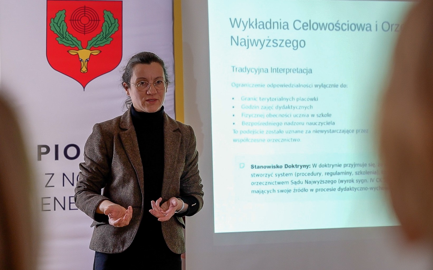 Prelegenci szkolenia z kompetencji Kobieta, szczupła, brunetka, upięte włosy, okulary